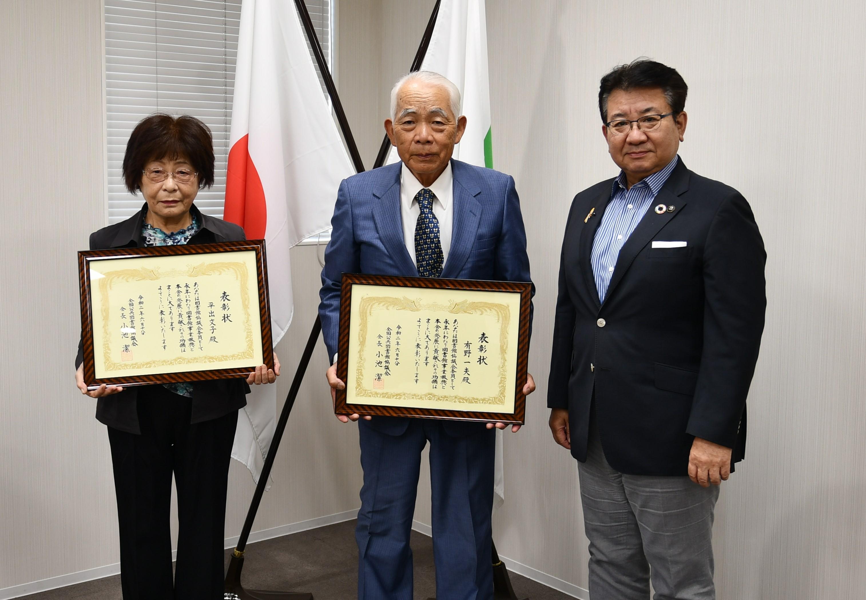 表彰状を手にする図書館協議会委員と市長