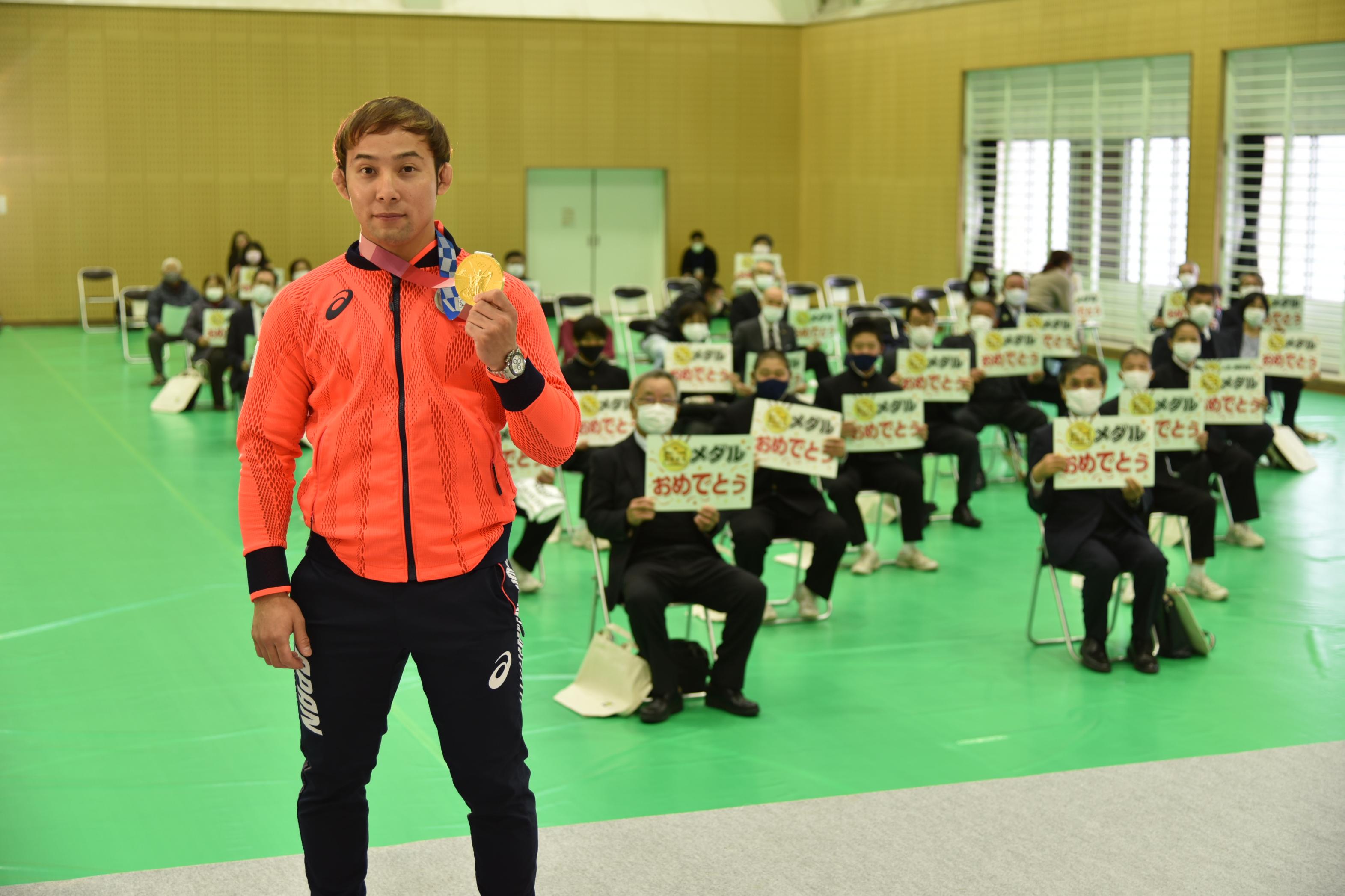 金メダルを見せる髙藤選手と会場の参加者で記念撮影 金メダルを見せる髙藤選手と会場の参加者で記念撮影
