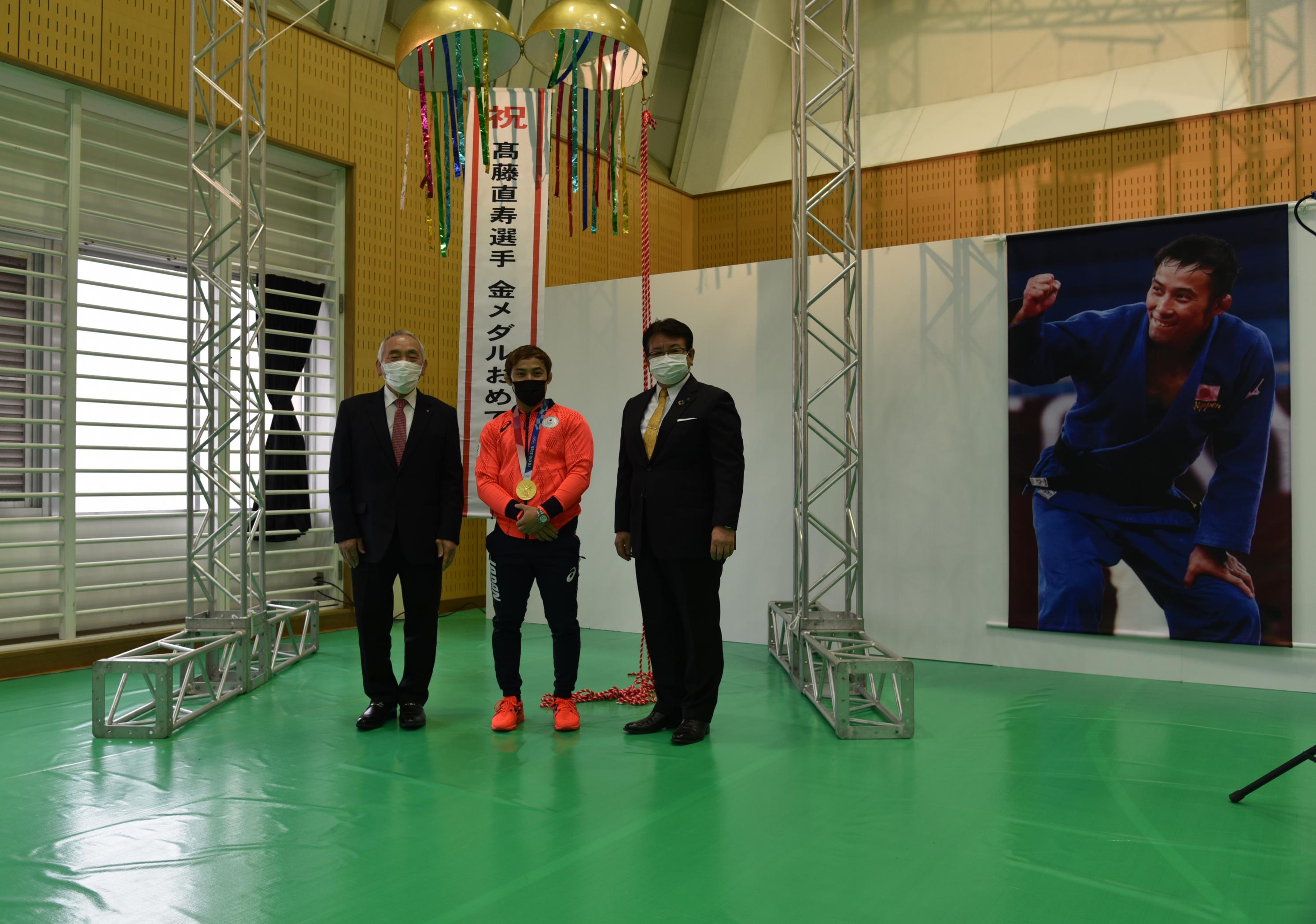 くす玉の下で記念撮影する髙藤選手、倉井後援会会長、広瀬市長 くす玉の下で記念撮影する髙藤選手、倉井後援会会長、広瀬市長