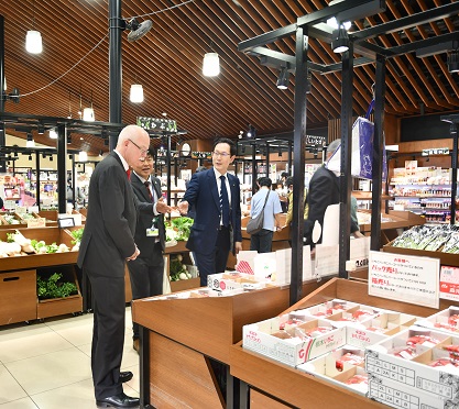 道の駅しもつけで特産品を視察する大使と案内する市長