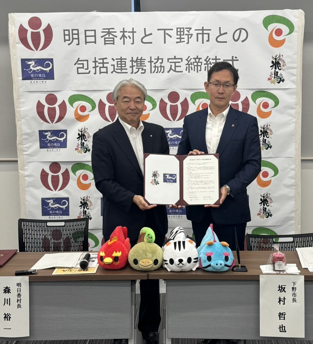 調印した協定書と記念品を手にする参加者の方々の写真